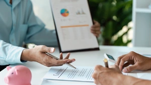 A young couple discussing financial planning and signature with Documents and Adviser Financial